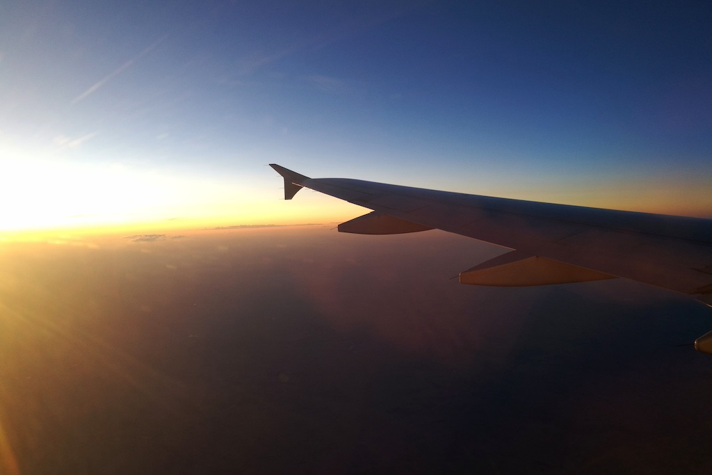 Flugreise: Ein Flugzeugflügel im Sonnenuntergang